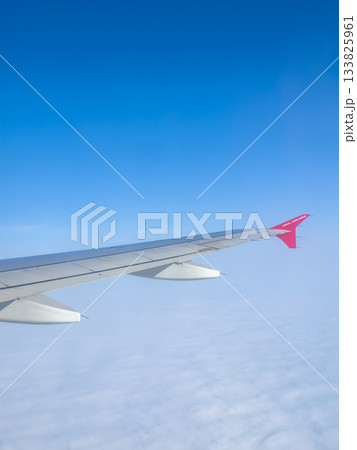 airplane wing over cloud sea, red wingtip, high-altitude view 133825961