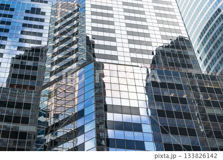 Reflective glass background. Architecture. Building architecture. Building background. Glass building window. Architectural detail. Background of architecture. Modern glass background Reflective glass background. Architecture. Building architecture. Building background. Glass building window. Architectural detail. Background of architecture. Modern glass background 133826142