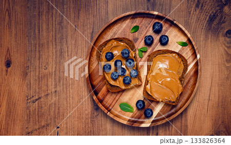 rye bread with peanut paste and fresh blueberries, top view, no people, rye bread with peanut paste and fresh blueberries, top view, no people, 133826364