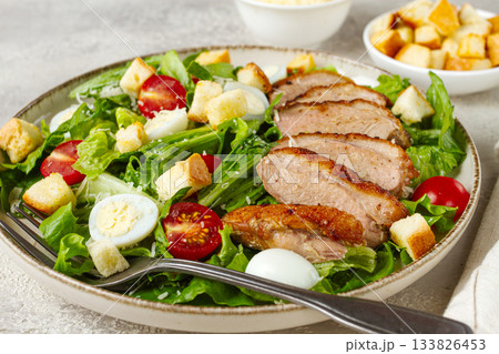 Caesar salad, with duck breast, on a light plate, on a light background, homemade, no people, 133826453