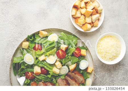 Caesar salad, with duck breast, on a light plate, on a light background, homemade, no people, 133826454