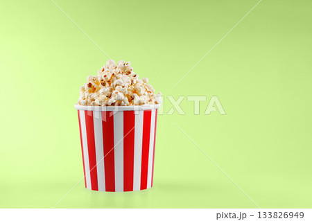 Classic red striped popcorn cardboard cup on Green background 133826949