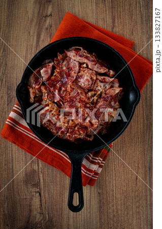 Crispy bacon, on a cast-iron skillet, on a wooden table, rustic style, no people Crispy bacon, on a cast-iron skillet, on a wooden table, rustic style, no people 133827167