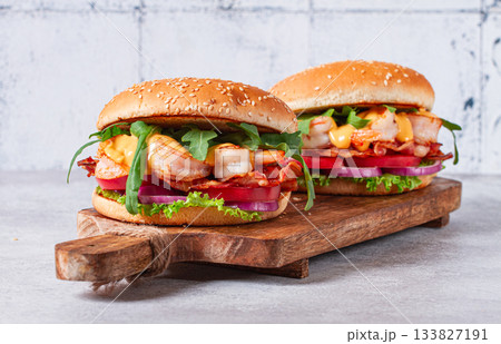 Shrimp burgers with fresh ingredients are served on a wooden board in a bright kitchen, 133827191