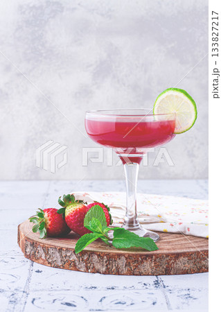 Refreshing cocktail in an elegant glass with lime and strawberries, sunshine, no people, 133827217