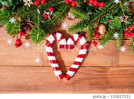 Christmas border with candy cane heart on wooden background Christmas border with candy cane heart on wooden background 133827231