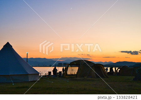 穏やかな夕景に包まれたキャンプサイトのシルエット 穏やかな夕景に包まれたキャンプサイトのシルエット 133828421
