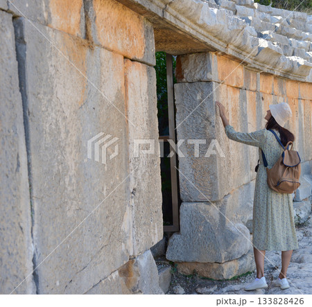 A woman tourist touches the ruins of the ancient Lycian city of Myra. Demre, Antalya, Turkey A woman tourist touches the ruins of the ancient Lycian city of Myra. Demre, Antalya, Turkey 133828426