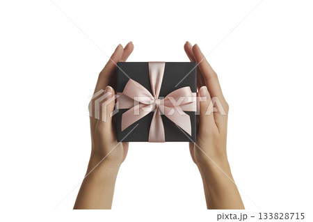 Pair of hands carefully presenting elegant black gift box tied with soft pink satin ribbon, symbolizing thoughtful present 133828715