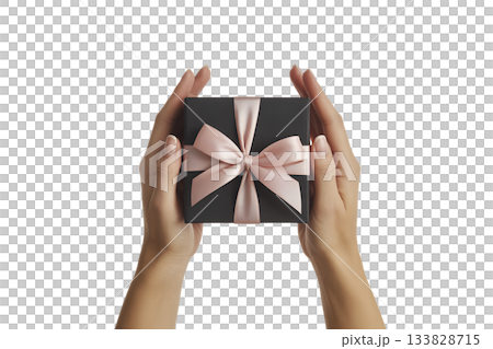 Pair of hands carefully presenting elegant black gift box tied with soft pink satin ribbon, symbolizing thoughtful present 133828715