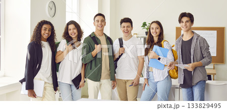 Group of a happy school or college students standing together in classroom and looking at camera. Group of a happy school or college students standing together in classroom and looking at camera. 133829495