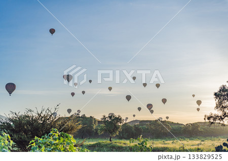 Colorful hot air balloons floating over Teotihuacan in Mexico, creating a breathtaking view of the ancient pyramids. Tourism, adventure, and cultural heritage concept 133829525