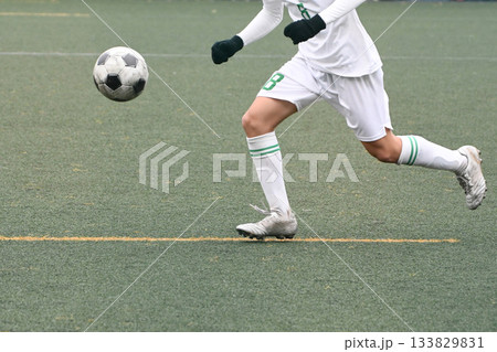 ドリブルするサッカー選手 133829831