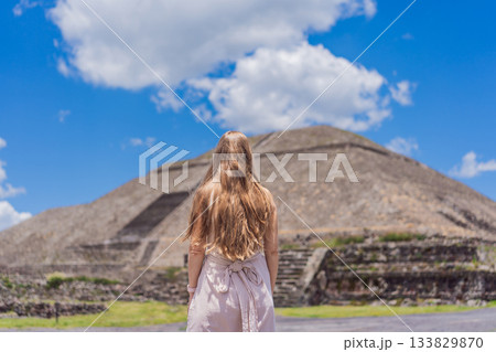 Female tourist standing in front of Teotihuacan pyramids in Mexico, enjoying sightseeing, adventure, and cultural heritage. Travel, tourism, and exploration concept Female tourist standing in front of Teotihuacan pyramids in Mexico, enjoying sightseeing, adventure, and cultural heritage. Travel, tourism, and exploration concept 133829870