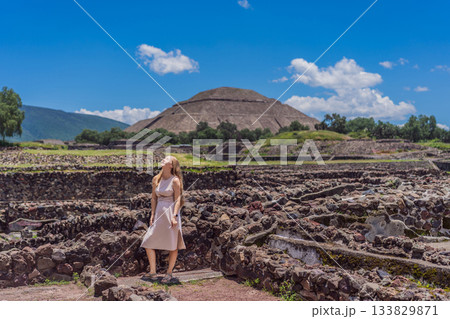 Female tourist standing in front of Teotihuacan pyramids in Mexico, enjoying sightseeing, adventure, and cultural heritage. Travel, tourism, and exploration concept 133829871