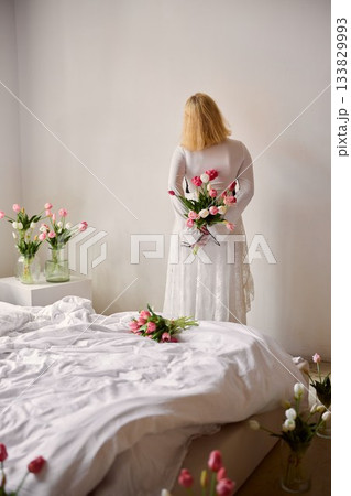 Fashionable blonde model with lace skirt and floral arrangement 133829993