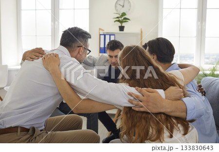 Group of business people putting hands on each others shoulders Group of business people putting hands on each others shoulders 133830643