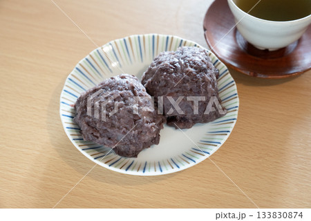 白い皿にのった2つのおはぎとお茶 133830874