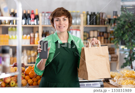 Saleswoman with phone and package Saleswoman with phone and package 133831989