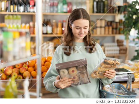 Teenage girl choosing cookies in grocery store Teenage girl choosing cookies in grocery store 133832034