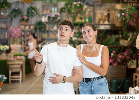 Married couple look for something in room garden furniture store, searching for item to complete patio. Woman with husband buyers looks around in showroom 133832048