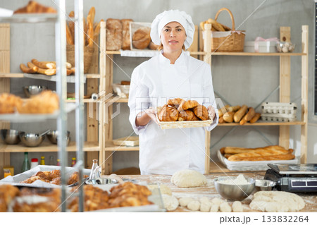 Adult female baker with basket of croissants Adult female baker with basket of croissants 133832264