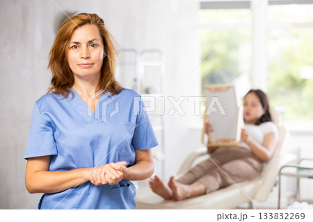 Woman beautician wearing blue overall posing in clinic of esthetic medicine 133832269