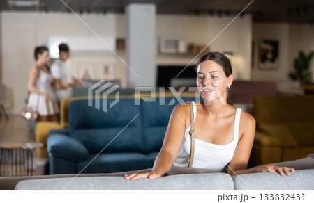 Young girl choosing convenient sofa in furniture shop Young girl choosing convenient sofa in furniture shop 133832431