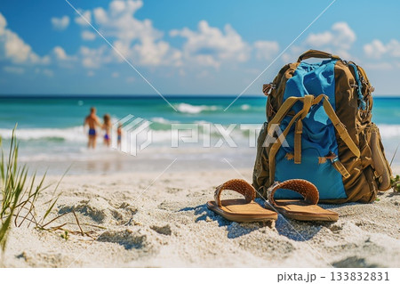 Close-Up View of Sandals and Backpack on the Beach with Family in the Background Close-Up View of Sandals and Backpack on the Beach with Family in the Background 133832831
