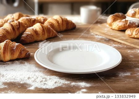 Freshly Baked Croissants and Baguettes on Wooden Table in Cozy Bakery Setup 133832949