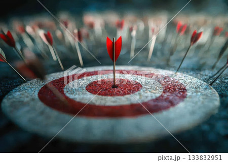 A red arrow is stuck in the center of a red and white target A red arrow is stuck in the center of a red and white target 133832951