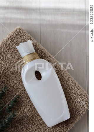 白い柔軟剤の容器とバスタオルとユーカリのフェイクグリーン 133833823
