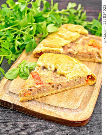 Galette with minced meat and peppers on black board 133834022