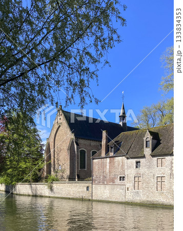 Old church by canal with trees in foreground 133834353