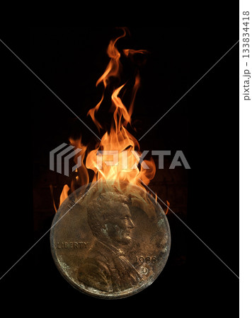 One old, antiquated penny burning in flames 133834418
