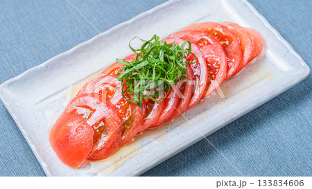 冷やしトマトの薄切りに青じそを添えた夏のさっぱり前菜 冷やしトマトの薄切りに青じそを添えた夏のさっぱり前菜 133834606