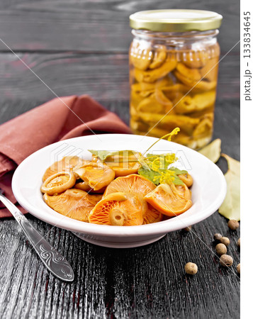 Mushrooms salted in plate on black wooden board Mushrooms salted in plate on black wooden board 133834645