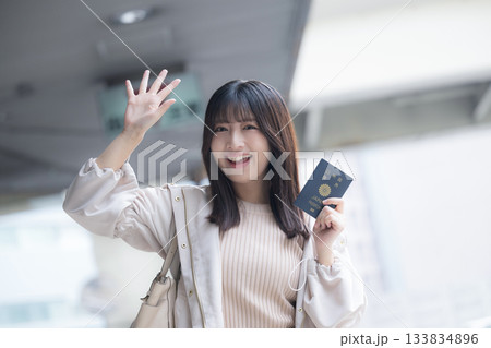 空港と駅や笑顔でパスポートを持つ女性 海外旅行へ行こう!バイバイと手を振る 空港と駅や笑顔でパスポートを持つ女性 海外旅行へ行こう!バイバイと手を振る 133834896