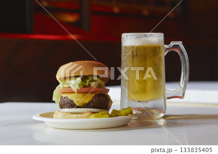 Cheeseburger and beer on restaurant table 133835405