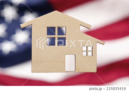 Wooden cutout of home with American flag background Wooden cutout of home with American flag background 133835419