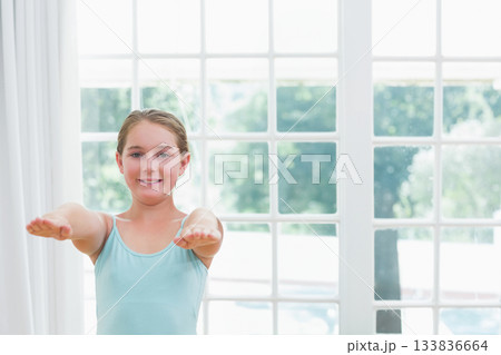 School-age girl in blue top extending arms horizontally at home by multi-pane window, copy space School-age girl in blue top extending arms horizontally at home by multi-pane window, copy space 133836664