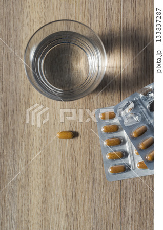Glass of water with pill blister packs 133837287