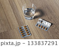 Glass of water with pill blister packs 133837291