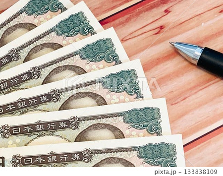 紙幣・お金（木目調テーブル背景） 133838109