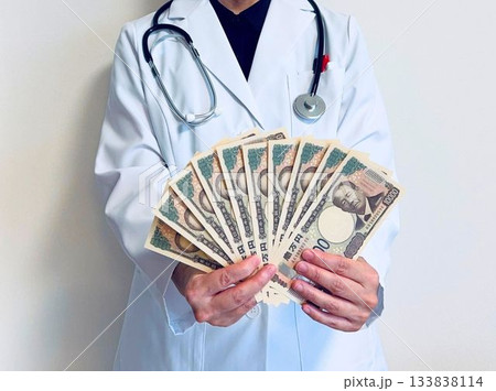 現金を扇状に持った医師 133838114