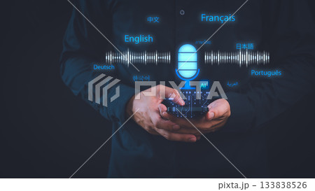 Man using smartphone with AI voice translation concept. Microphone icon, sound waves, multiple languages illustrate speech recognition, multilingual translation and artificial intelligence technology. 133838526