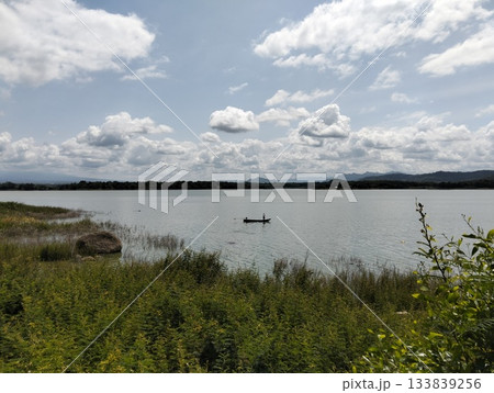 Serene Lake View with Distant Mountains and a Lone Boat Serene Lake View with Distant Mountains and a Lone Boat 133839256