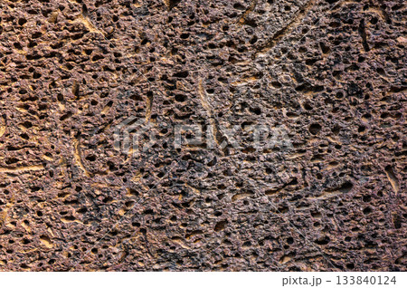 Close up detailed texture of rough red porous laterite stone surface used in ancient temple construction walls Close up detailed texture of rough red porous laterite stone surface used in ancient temple construction walls 133840124