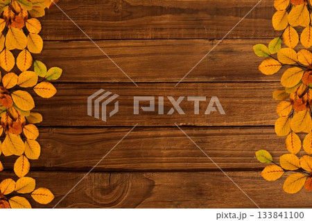 Showcasing rustic wooden plank surface with autumn leaf clusters framing sides in flat design 133841100