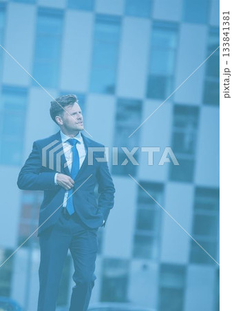 Businessman walking against building Businessman walking against building 133841381